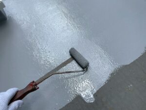 福山市周辺の住宅ベランダでFRP防水トップコートを施工している様子