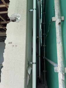 外壁塗装で建物との間が狭い場所に足場を設置している様子