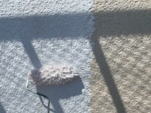 モルタル外壁に下塗り材をローラーで施工している様子