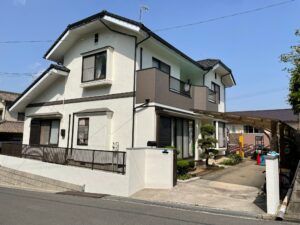 アイボリー系の外壁とブラウン系のベランダ、黒系の屋根や付帯部を組み合わせたユウキ塗装の施工例